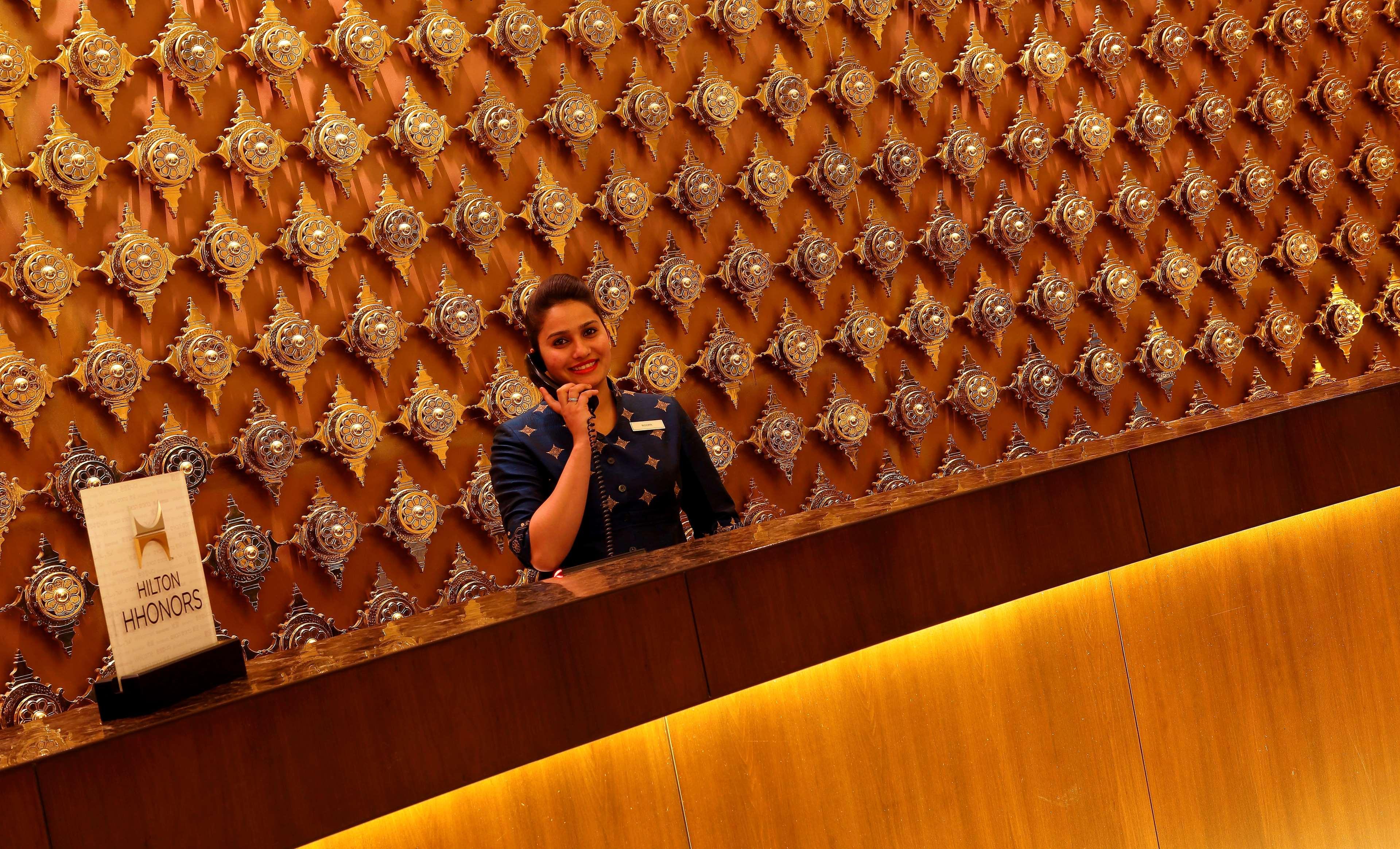 Hilton Jaipur Hotel Eksteriør billede A hotel receptionist at work